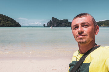 Man tourist on beach in turquoise water Koh Phi Phi Thailand.