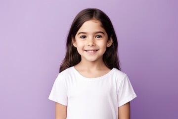Portrait of smiling little girl in white t-shirt on purple background