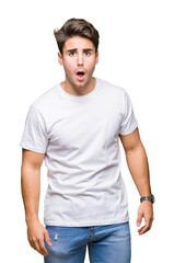 Fototapeta premium Young handsome man wearing white t-shirt over isolated background In shock face, looking skeptical and sarcastic, surprised with open mouth