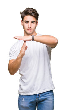 Young handsome man wearing white t-shirt over isolated background Doing time out gesture with hands, frustrated and serious face