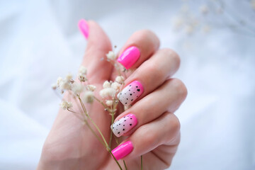 Women's hands with a fashionable pink manicure hold dried flowers in their hands. Spring - summer...