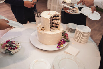 Waiters cut the wedding cake. Banquet. Piece of wedding cake. detail of luxury wedding Dessert. cutting cake with colouring sugar. Cut slice of celebrating cake.