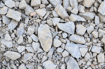 Abstract background with crushed gravel and small little grey rocks and stones, close-up view from...