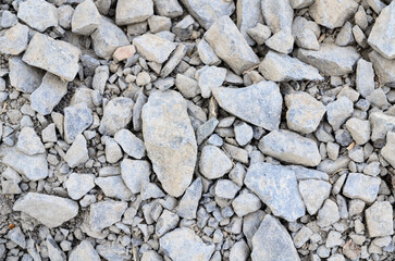 Abstract background with crushed gravel and small little grey rocks and stones, close-up view from directly above
