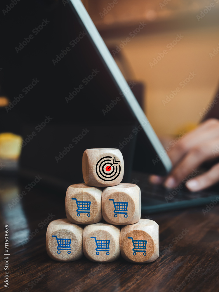 Poster target icon on top of wooden cube block stack pyramid shape with shopping cart icons while businessm