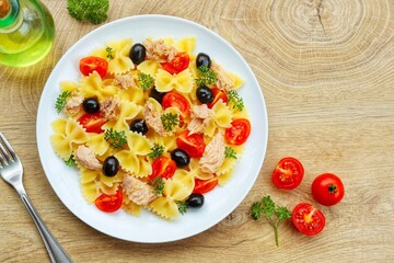 Farfalle pasta salad with canned tuna in olive oil, cherry tomatoes,black olives,parleys,olive oil...