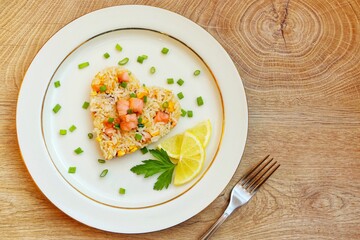 Heart shaped salmon fried rice,jasmine rice with smoked salmon,garlics,onions,spring onions,eggs and soy sauce on plate with wooden background.Love healthy food concept for Valentine's day.Top view