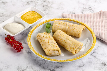 Homemade stuffed pancakes with honey and cream sour