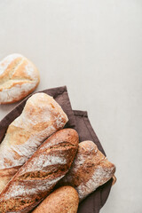 Assorted bakery products including loafs of bread,  baguette and rolls in basket