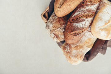 Assorted bakery products including loafs of bread,  baguette and rolls in basket