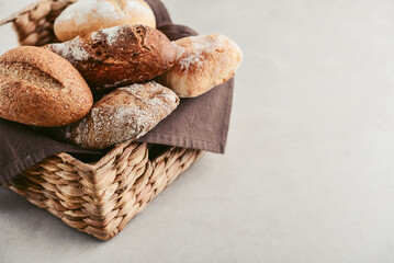 Assorted bakery products including loafs of bread,  baguette and rolls in basket