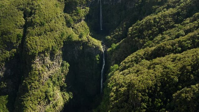 Scenic drone footage of a cascading waterfall in mountains of Madeira Portugal