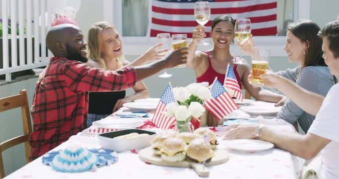 Friends, alcohol and cheers at party, American flag and celebration for Independence Day with bbq outdoor. Diversity, fun with beer and wine on fourth of July, holiday and people with toast in USA