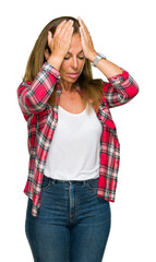 Middle age adult woman wearing casual shirt over isolated background suffering from headache desperate and stressed because pain and migraine. Hands on head.