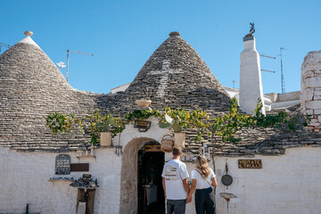 Fototapeta na wymiar Tourist couple in the beautiful village of Alberobello in Italy