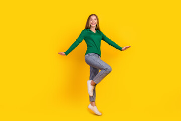 Fototapeta na wymiar Full body length photo of charming girl teenager in green jumper denim jeans white sneakers freedom isolated on yellow color background