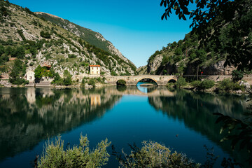 Fototapeta na wymiar Beautiful calm lake with bridge - Lago di San Domenico near Scanno in Abruzzo, Italy