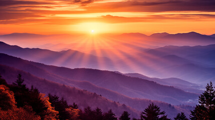 Obraz premium A captivating smoky mountain sunset scene, with the sun casting a warm, golden glow over the rugged peaks