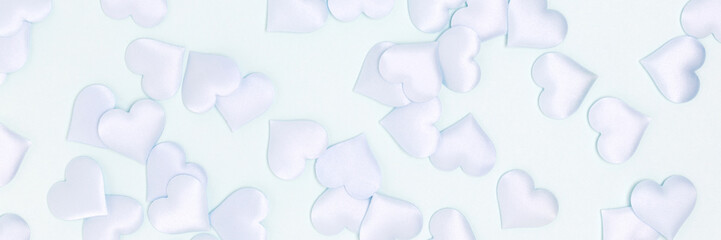 Banner with texture made of confetti in a heart shape on a blue background. Monochrome concept.