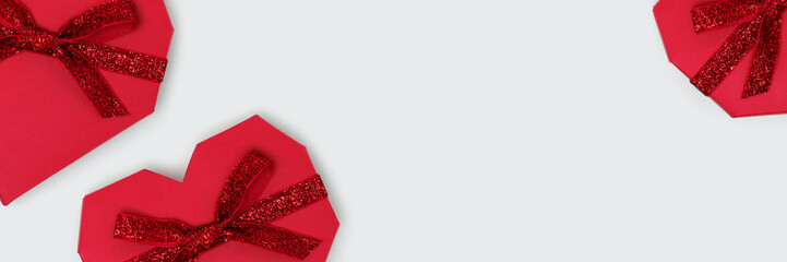 Banner with red gift box in a heart shape with tied ribbon. Festive composition on a blue...