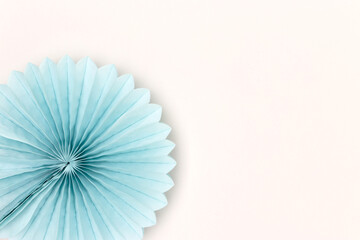 Blue tissue paper fan on a gray background. Creative minimal layout.