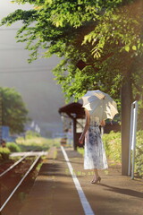 鳥取県若桜鉄道、安倍駅は真っ直ぐに伸びる線路の景観が素晴らしく｢男はつらいよ｣のロケ地にもなった駅舎です。夏の午後の日差しの中に、輝く線路と日傘の旅行者のシルエット