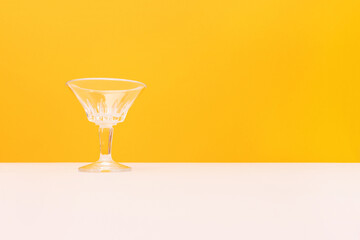Crystal glass in front of yellow background. Copy space.