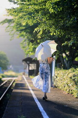 鳥取県若桜鉄道、安倍駅は真っ直ぐに伸びる線路の景観が素晴らしく｢男はつらいよ｣のロケ地にもなった駅舎です。夏の午後の日差しの中に、輝く線路と日傘の旅行者のシルエット