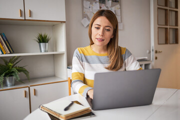 Caucasian female freelancer working on netbook at home office