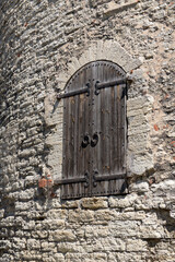 Antique door in the castle, stone wall, sunny day, reliable lock