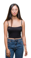 Obraz premium Young asian woman wearing glasses over isolated background with serious expression on face. Simple and natural looking at the camera.