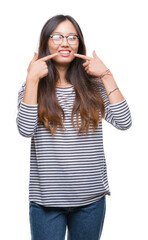 Fototapeta premium Young asian woman wearing glasses over isolated background smiling confident showing and pointing with fingers teeth and mouth. Health concept.