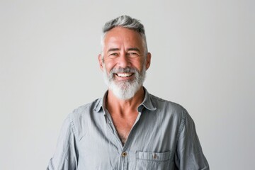 Fototapeta premium Portrait of smiling mature man standing on white background.