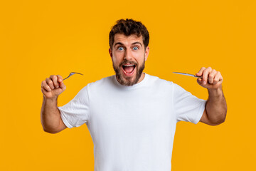 Emotional man holding knife and fork ready to eat, studio