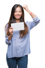 Fototapeta premium Young asian woman holding blank card over isolated background annoyed and frustrated shouting with anger, crazy and yelling with raised hand, anger concept