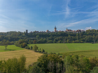 Fototapeta na wymiar Bad Wimpfen with a view of the old church and the historic city wall over fields, drone shoot