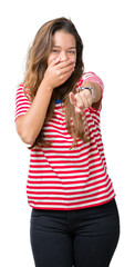 Young beautiful brunette woman wearing stripes t-shirt over isolated background Laughing of you, pointing to the camera with finger hand over mouth, shame expression