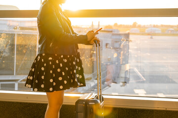 A woman is checking the departure time at the airport in sunlight,