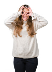 Obraz na płótnie Canvas Young beautiful brunette woman wearing turtleneck sweater over isolated background doing ok gesture like binoculars sticking tongue out, eyes looking through fingers. Crazy expression.