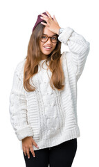Young beautiful brunette hipster woman wearing glasses and winter hat over isolated background...