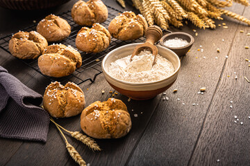 Homemade spelt bread buns with salt on wooden background