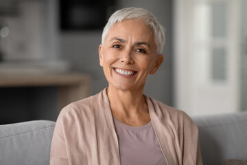 older woman with short haircut and gray hair posing indoors