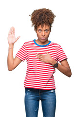 Beautiful young african american woman over isolated background Swearing with hand on chest and open palm, making a loyalty promise oath