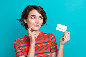 Photo of lovely smart woman dressed striped t-shirt holding debit card look at offer empty space...