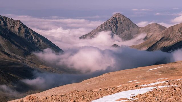 Majestic view of a mountain valley filled with clouds. Time lapse zoom in