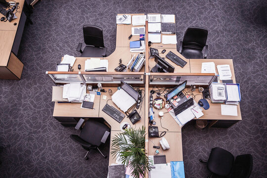 Topshot of unoccupied workspaces and desks in a large open office space. Cape Town, South Africa