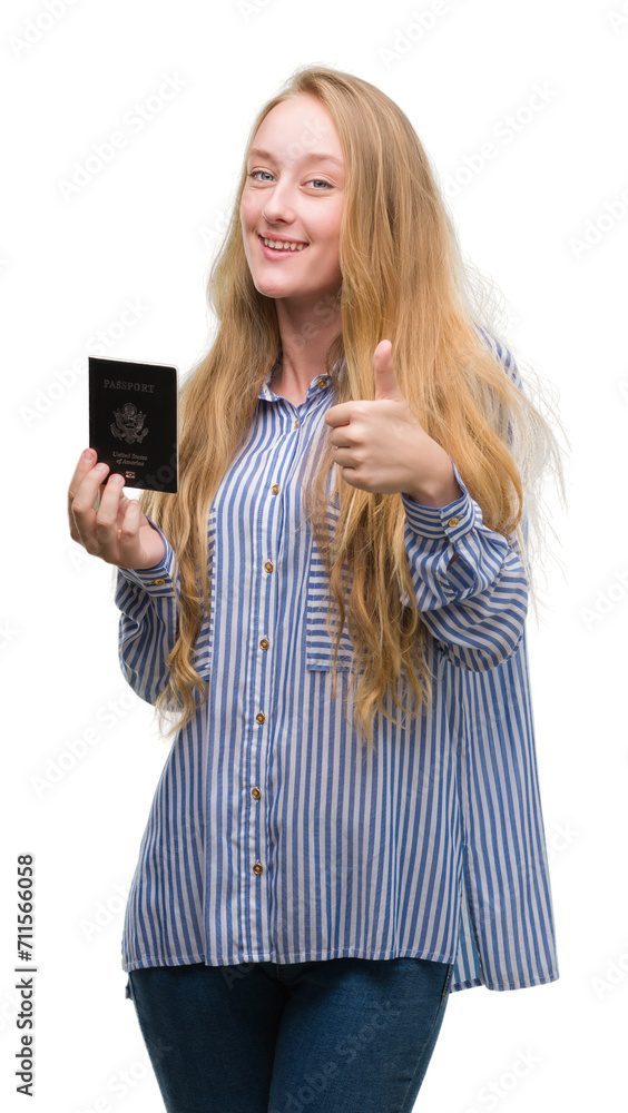 Sticker Blonde teenager woman holding passport of Unites States of America happy with big smile doing ok sign, thumb up with fingers, excellent sign