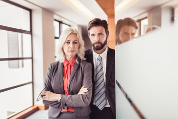 Two colleagues standing in a conference room door at the office..