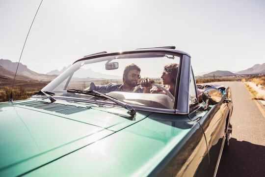 Paar in Ford Mustang Cabrio auf weiter Strasse, Franschhoek, S&uuml;dafrika