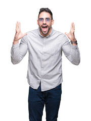 Young handsome man wearing sunglasses over isolated background celebrating crazy and amazed for success with arms raised and open eyes screaming excited. Winner concept